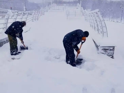 Сотрудники организации «Мурманские городские парки и скверы» убирают город в период снегопада